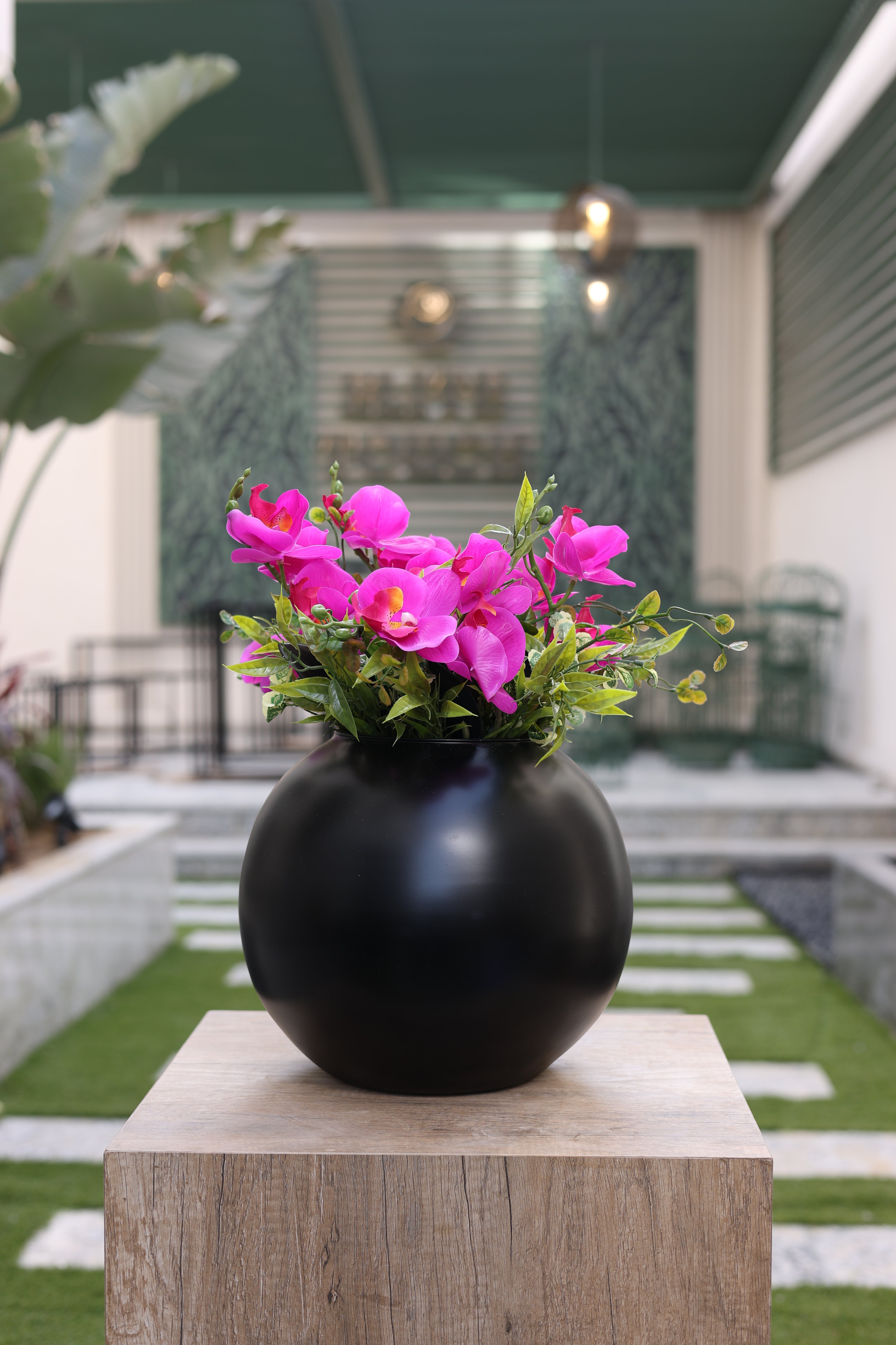 purple artificial orchid flowers in circular black vase Egypt