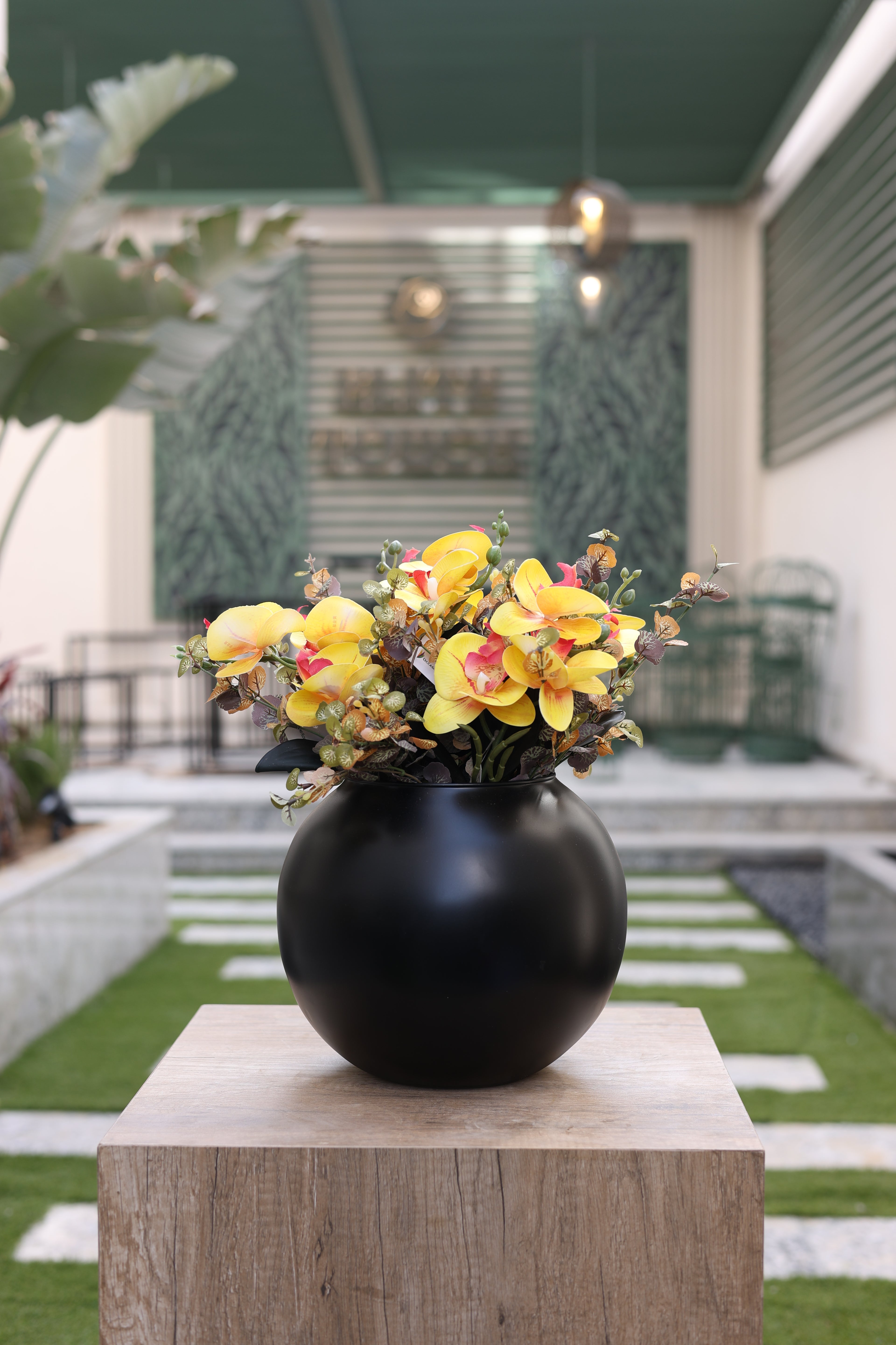 yellow artificial orchid flowers in circular black vase Egypt