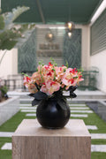 multi-color artificial orchid flowers in circular black vase Egypt