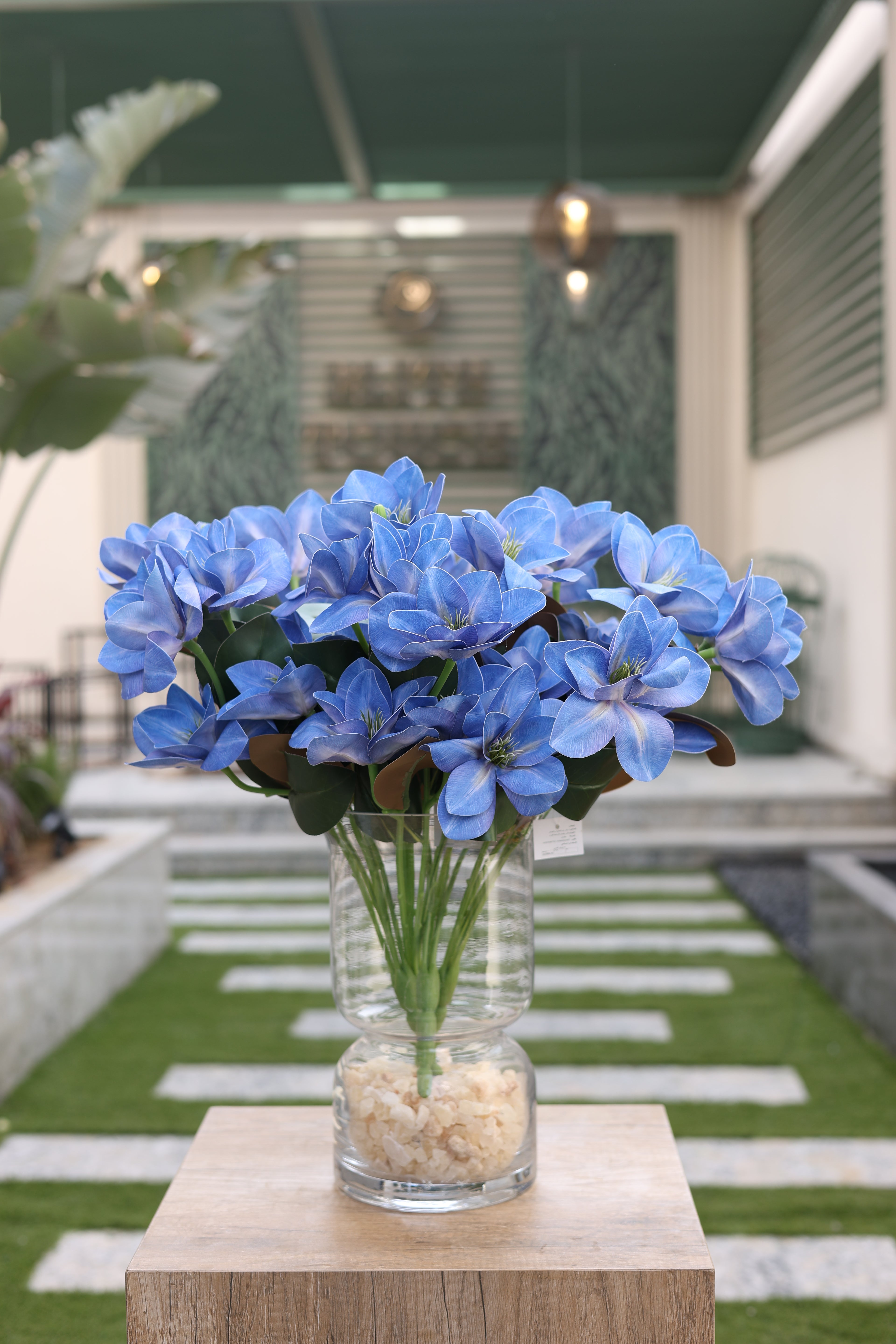 blue artificial magnolia flowers in glass vase Egypt