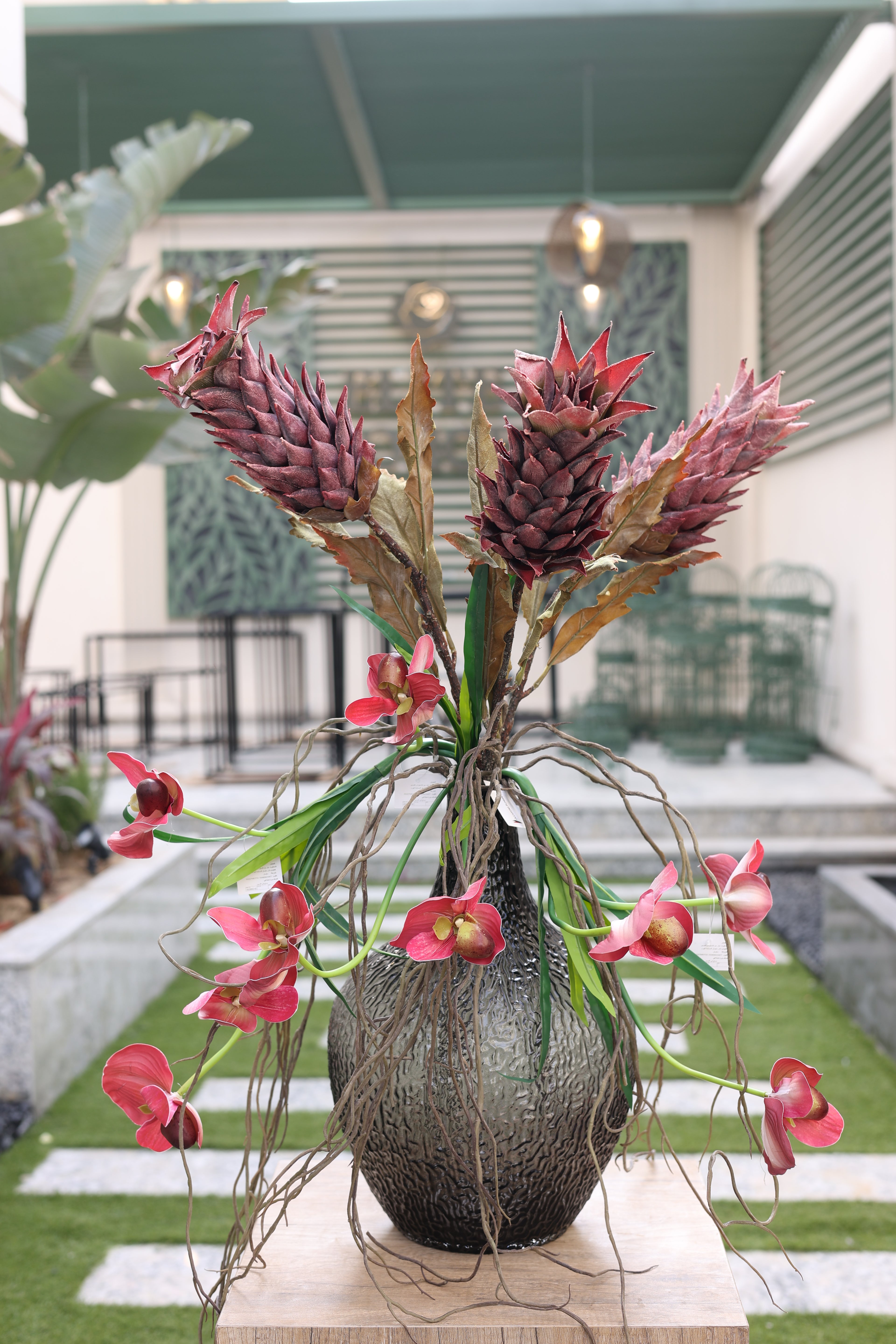 artificial pineapple and baby orchid in glass vase Egypt