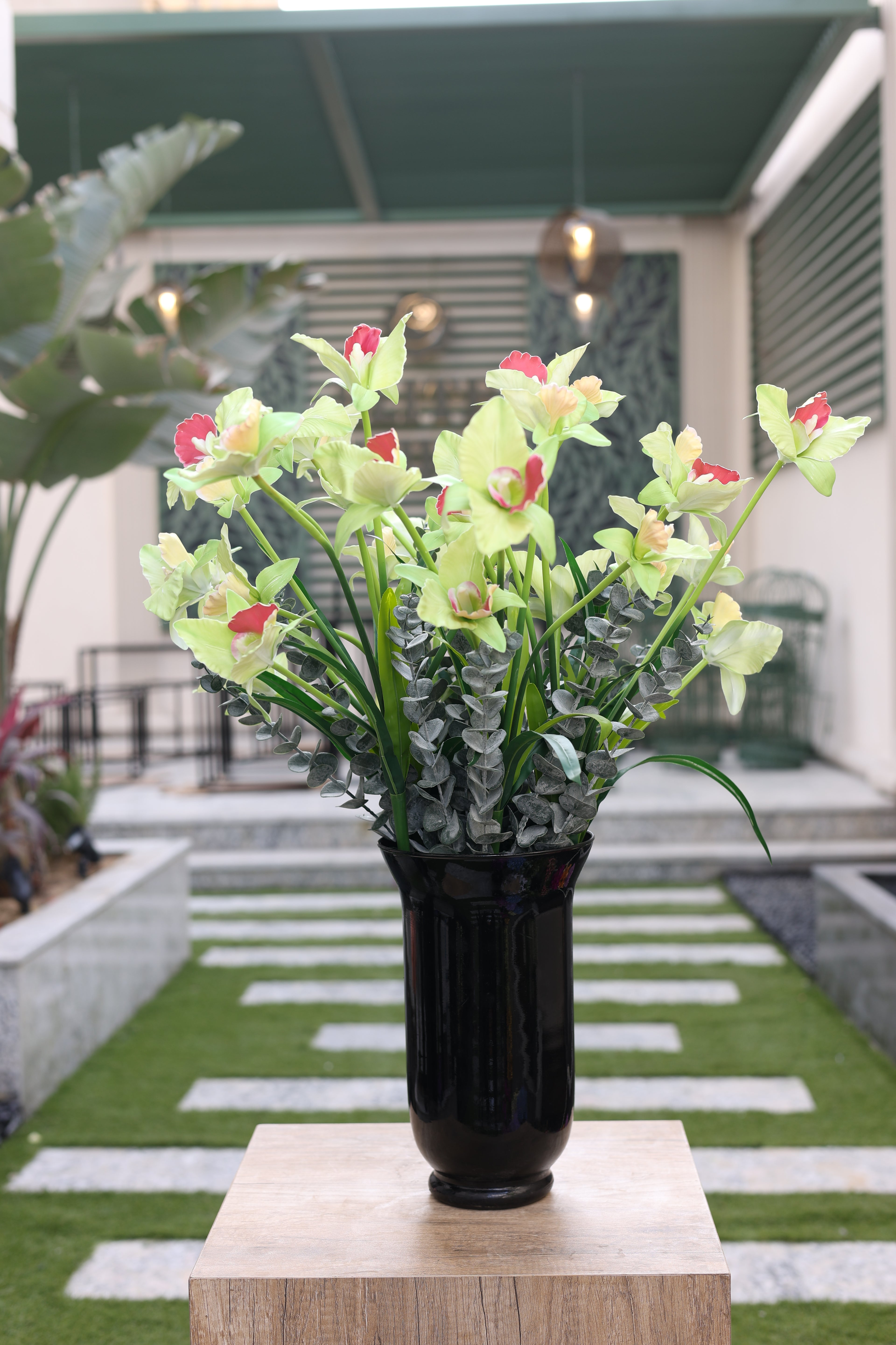 artificial orchid and green foliage in glass vase Egypt
