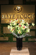 medium artificial baby orchid and green foliage in glass vase Egypt