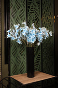 standard artificial orchid and green foliage in glass vase Egypt