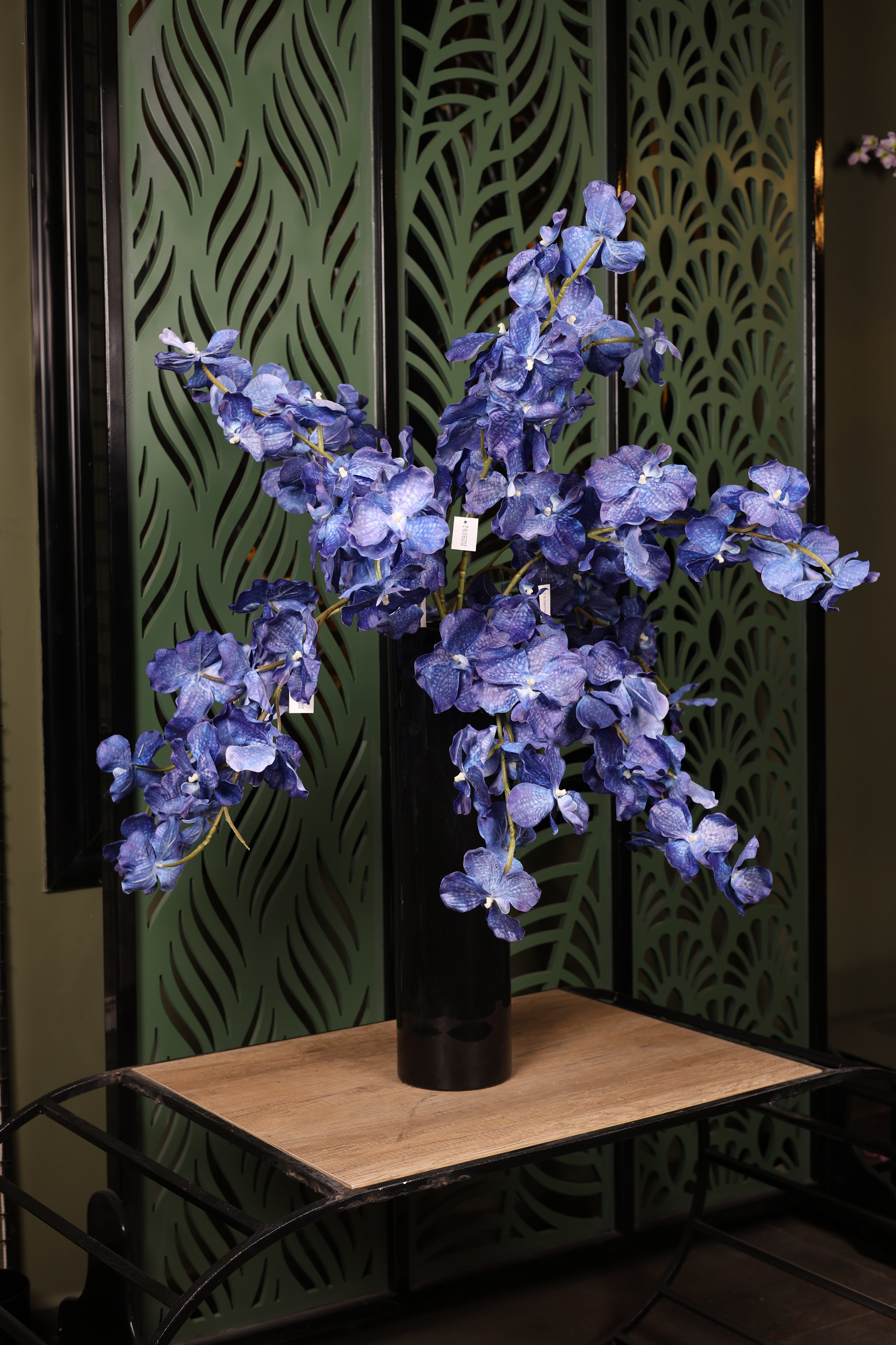 basic artificial orchid and green foliage in glass vase Egypt