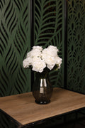 Enhanced mixed artificial flower arrangement in a clear glass vase, placed in a fuller modern Egyptian interior.
