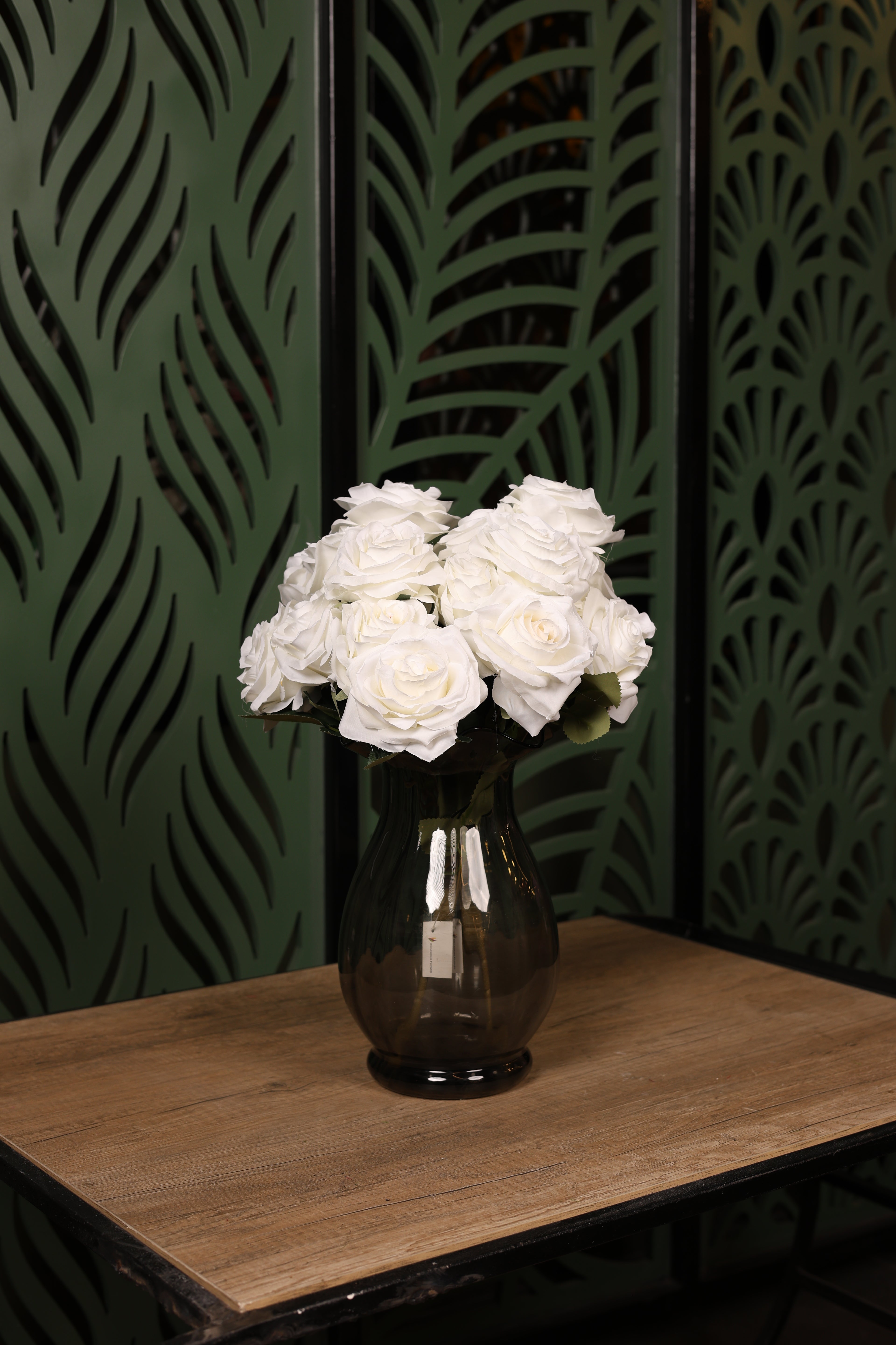 Enhanced mixed artificial flower arrangement in a clear glass vase, placed in a fuller modern Egyptian interior.